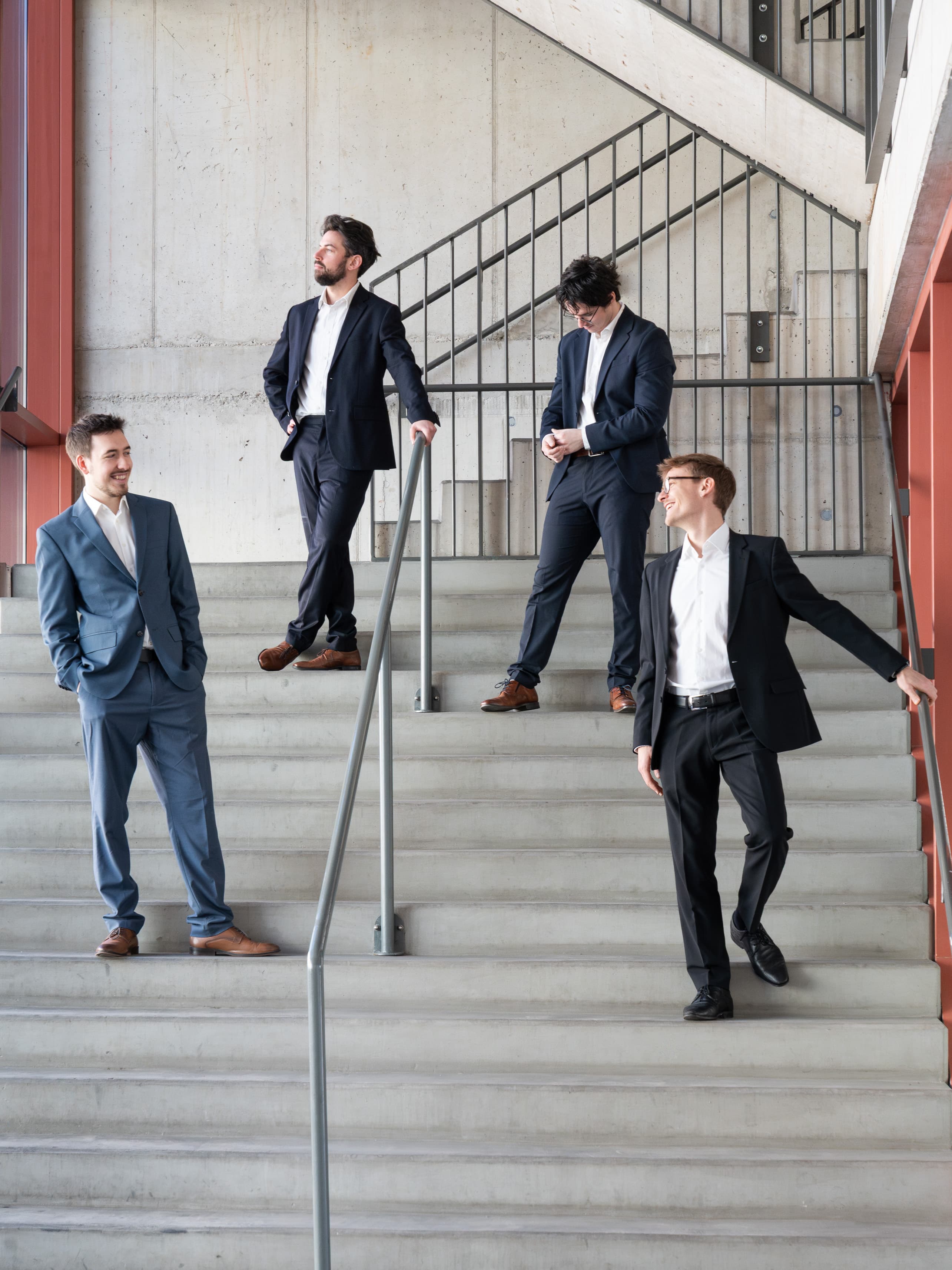 Das Männerquartett halb8 auf einer großen Treppe.